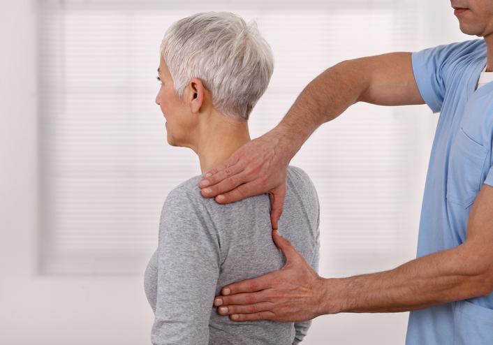 Femme sénior consultant un ostéopathe